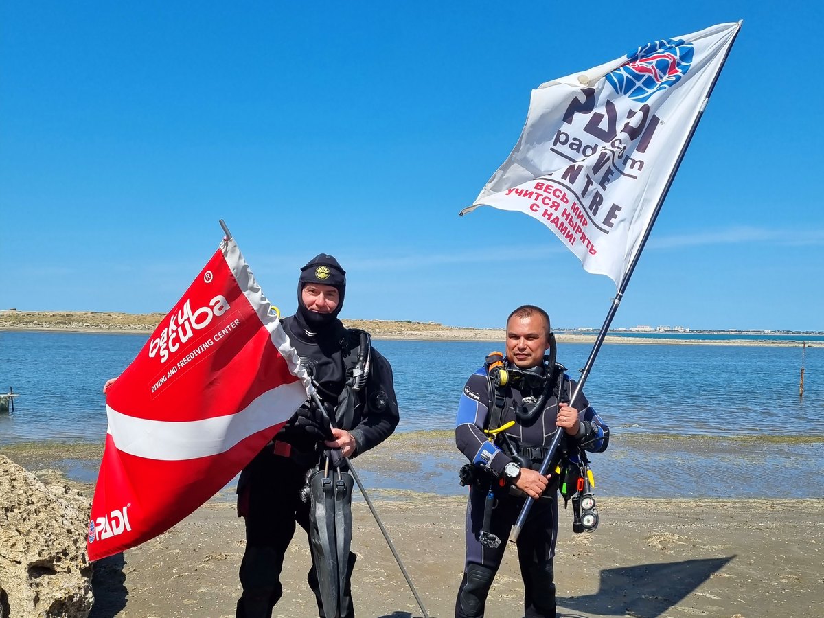 Baku Scuba instructors with PADI and Baku Scuba flags on the Caspian shore